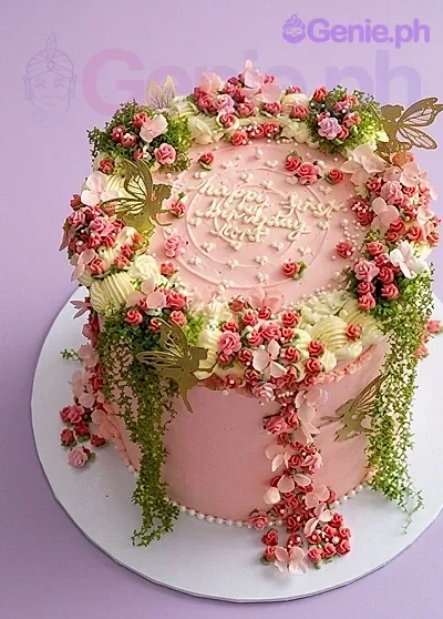 A pink and white 1-tier Floral Garden cake with gold butterflies, piped rosettes, green moss textures, and white pearl sprinkles. A pink and white 1-tier Floral Garden cake with gold butterflies, piped rosettes, green moss textures, and white pearl sprinkles.