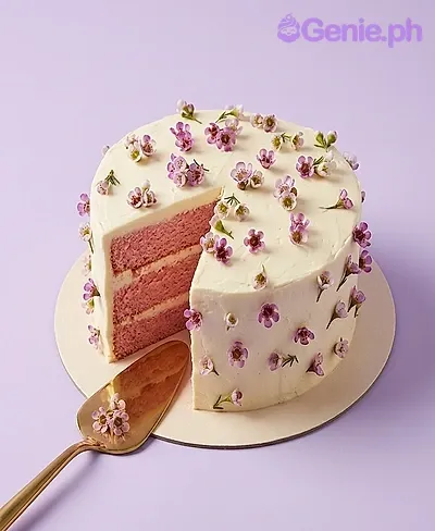 A white 1 Tier cake themed around Floral Minimalist, adorned with small purple and white edible flowers. A white 1 Tier cake themed around Floral Minimalist, adorned with small purple and white edible flowers.