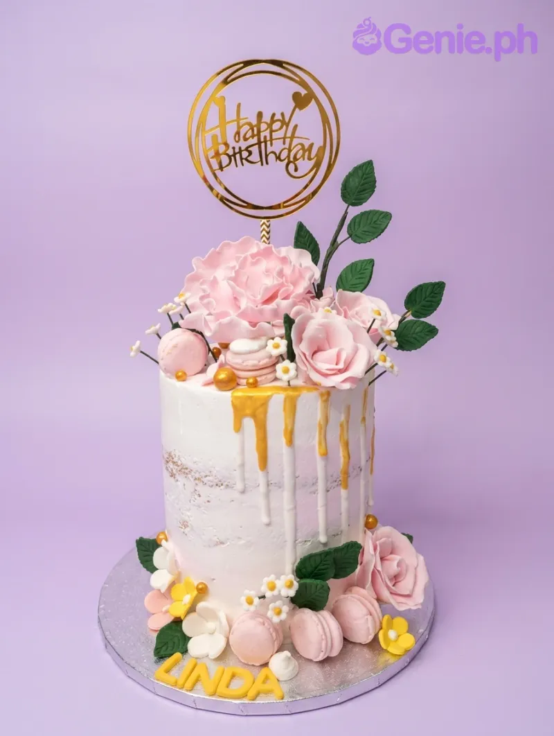 Tall white semi-naked cake with pink gumpaste roses, macarons, gold drips, and a gold Happy Birthday topper. Tall white semi-naked cake with pink gumpaste roses, macarons, gold drips, and a gold Happy Birthday topper.