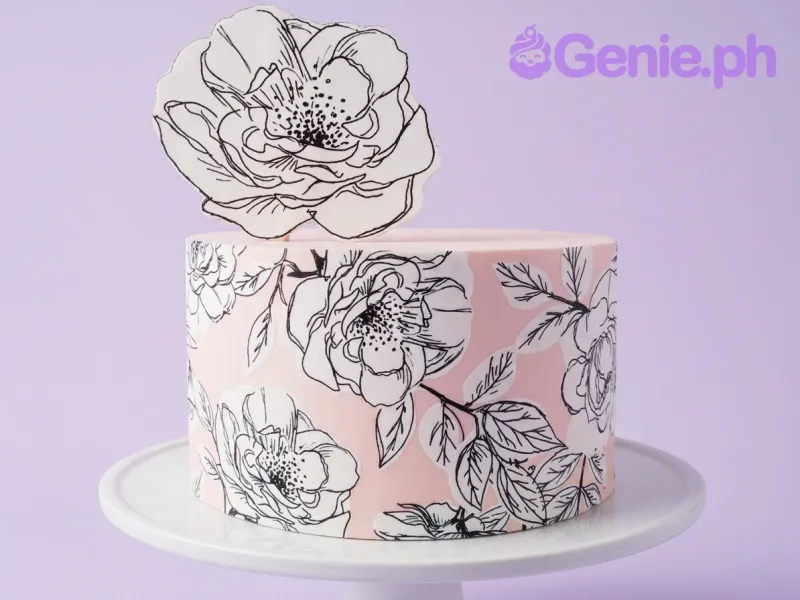 A pink, white, and black single tier cake themed around Floral Print, featuring a large floral printout and a black and white floral pattern side wrap. A pink, white, and black single tier cake themed around Floral Print, featuring a large floral printout and a black and white floral pattern side wrap.
