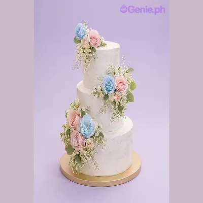Three tier white fondant cake with blue and pink sugar roses and baby's breath Three tier white fondant cake with blue and pink sugar roses and baby's breath