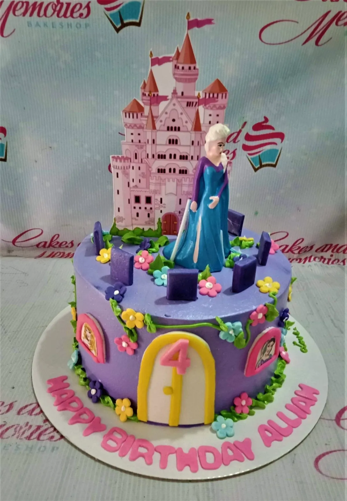 A Purple and Pink 1 Tier cake themed around Frozen Elsa, featuring a pink castle printout and an Elsa figurine with fondant flowers. A Purple and Pink 1 Tier cake themed around Frozen Elsa, featuring a pink castle printout and an Elsa figurine with fondant flowers.