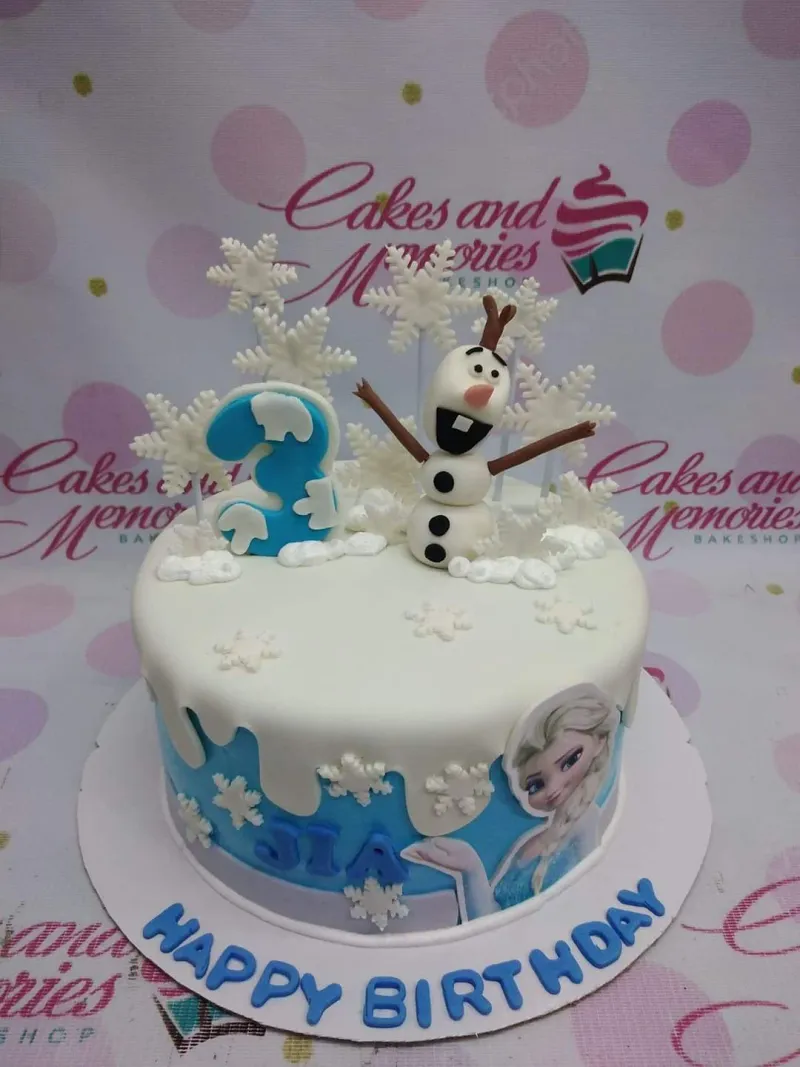 A blue and white 1 Tier Fondant cake themed around Frozen Olaf, featuring a 3D Olaf figure, Elsa printout, and blue number three, with white fondant snowflakes and snow mounds. A blue and white 1 Tier Fondant cake themed around Frozen Olaf, featuring a 3D Olaf figure, Elsa printout, and blue number three, with white fondant snowflakes and snow mounds.