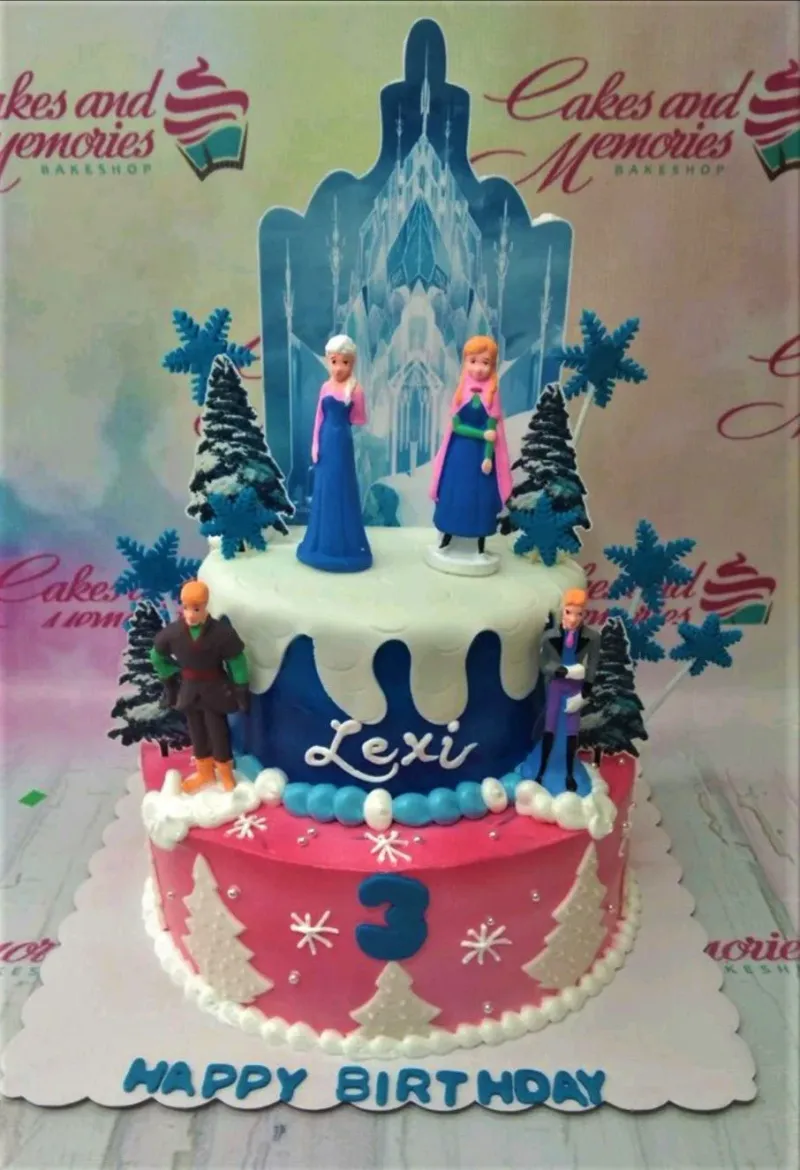 A blue, pink, and white two-tier cake themed around Frozen, featuring Elsa, Anna, Kristoff, and Hans figurines and snowflake decorations. A blue, pink, and white two-tier cake themed around Frozen, featuring Elsa, Anna, Kristoff, and Hans figurines and snowflake decorations.