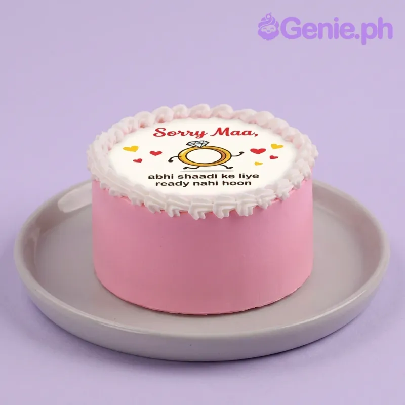 A pink and white 1-tier cake, Funny Marriage themed, featuring a cartoon running ring printout, message, and white rosette border. A pink and white 1-tier cake, Funny Marriage themed, featuring a cartoon running ring printout, message, and white rosette border.