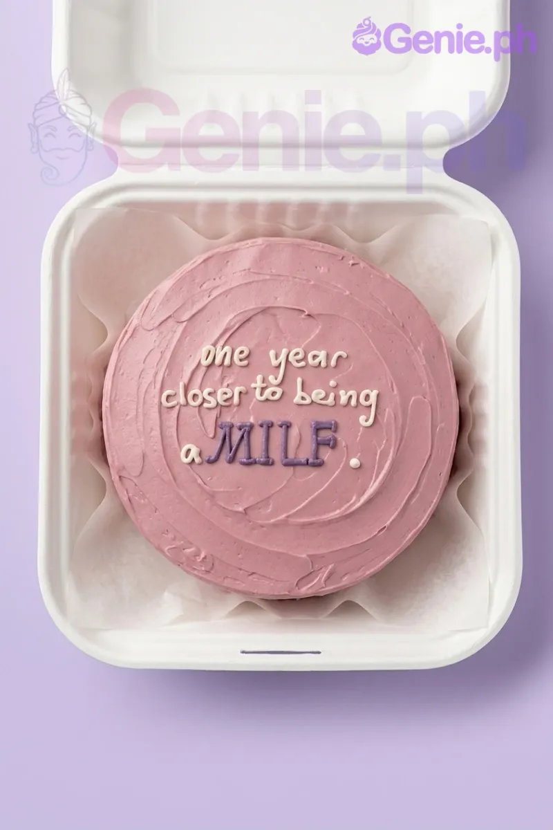 A pink bento cake with textured icing, featuring the humorous message 'one year closer to being a MILF.' in purple and white. A pink bento cake with textured icing, featuring the humorous message 'one year closer to being a MILF.' in purple and white.