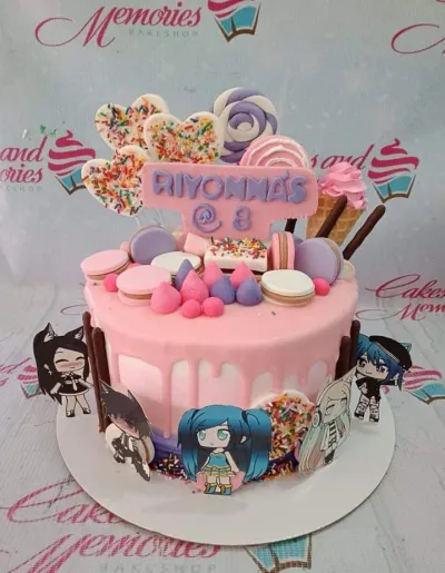 A pink 1-tier Gacha Life cake with character printouts, a 'RIYONNA'S @ 8' plaque, macarons, and meringue kisses. A pink 1-tier Gacha Life cake with character printouts, a 'RIYONNA'S @ 8' plaque, macarons, and meringue kisses.
