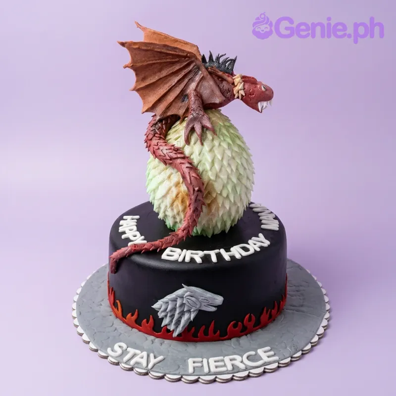 A black 1-tier fondant cake themed around Game Of Thrones, featuring a dragon on a textured egg, and a Stark sigil. A black 1-tier fondant cake themed around Game Of Thrones, featuring a dragon on a textured egg, and a Stark sigil.