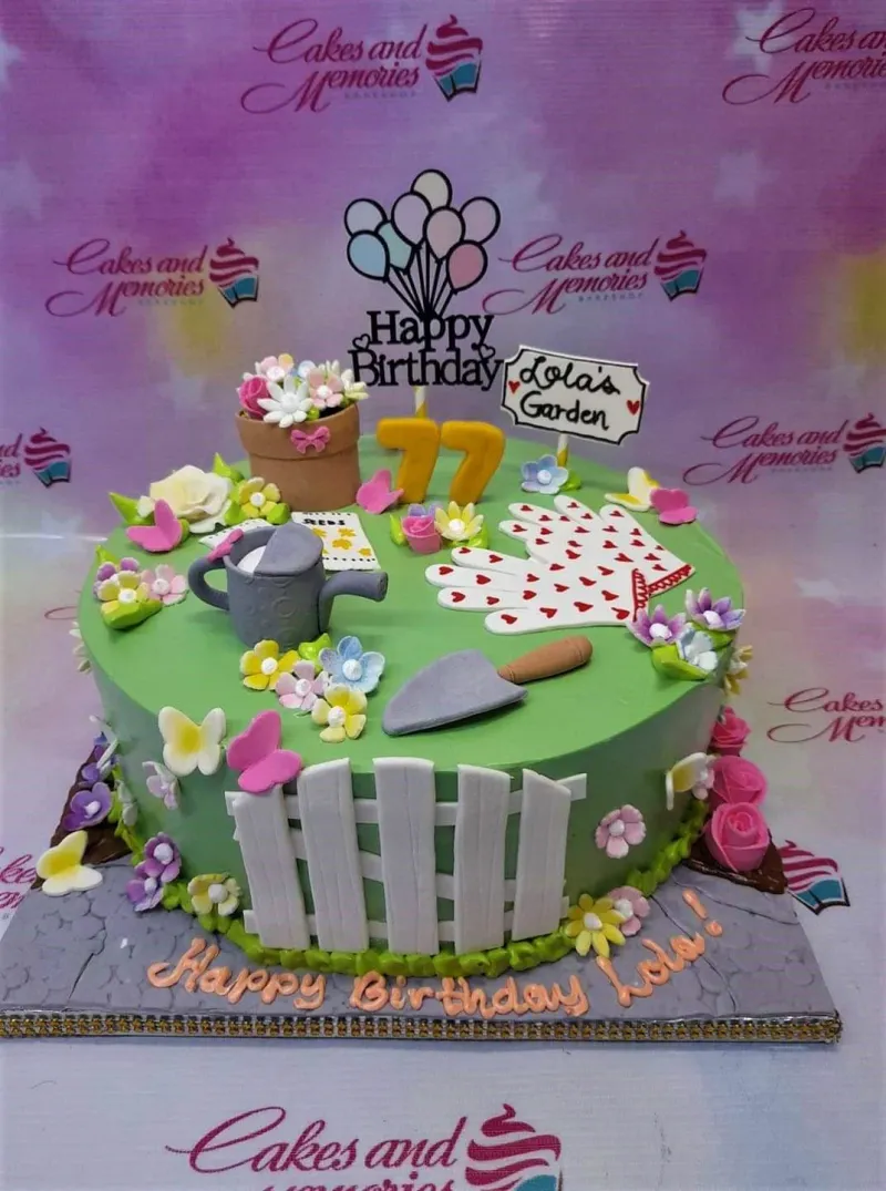 A green 1 Tier Fondant cake themed around Garden, featuring a flower pot topper, gardening tools, and a white picket fence. A green 1 Tier Fondant cake themed around Garden, featuring a flower pot topper, gardening tools, and a white picket fence.