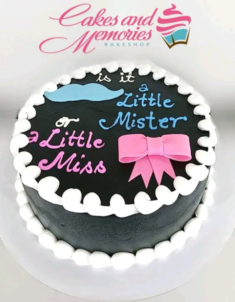 A black 1 Tier cake themed for Gender Reveal, featuring a blue mustache, a pink bow, white rosettes, and a message. A black 1 Tier cake themed for Gender Reveal, featuring a blue mustache, a pink bow, white rosettes, and a message.