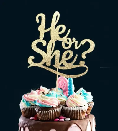 Gender reveal cake with chocolate drip, pink and blue icing swirls, and a gold glitter 'He or She?' topper. Gender reveal cake with chocolate drip, pink and blue icing swirls, and a gold glitter 'He or She?' topper.