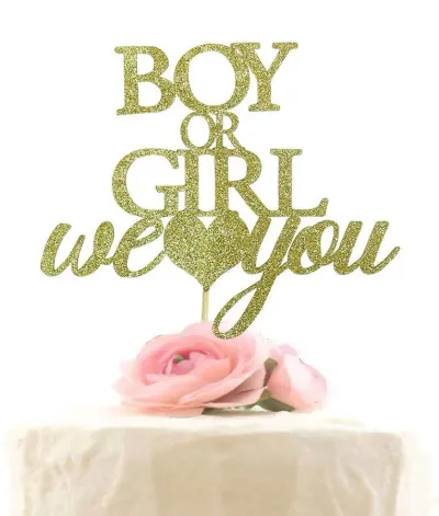 A white 1-tier Gender Reveal cake, featuring a large gold glitter 'Boy or Girl we love you' topper and pink artificial roses. A white 1-tier Gender Reveal cake, featuring a large gold glitter 'Boy or Girl we love you' topper and pink artificial roses.