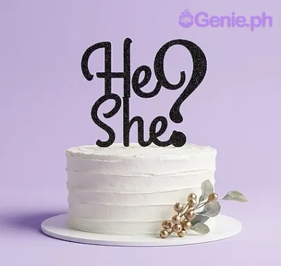 A white minimalist 1-tier gender reveal cake with a black glittery He or She question mark topper and gold floral accents. A white minimalist 1-tier gender reveal cake with a black glittery He or She question mark topper and gold floral accents.