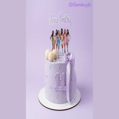 Lavender 1-tier cake with a girl group printout, name printout, number printout, pink satin ribbon bow, white fondant balls, and piped icing rosettes Lavender 1-tier cake with a girl group printout, name printout, number printout, pink satin ribbon bow, white fondant balls, and piped icing rosettes