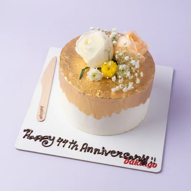 White and gold 1-tier cake with smooth icing, topped with white and peach roses, yellow chrysanthemums, and baby's breath. White and gold 1-tier cake with smooth icing, topped with white and peach roses, yellow chrysanthemums, and baby's breath.