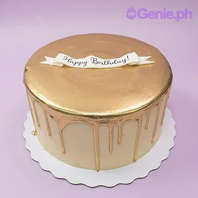 Gold and white single-tier cake with a Happy Birthday banner and gold drip icing Gold and white single-tier cake with a Happy Birthday banner and gold drip icing