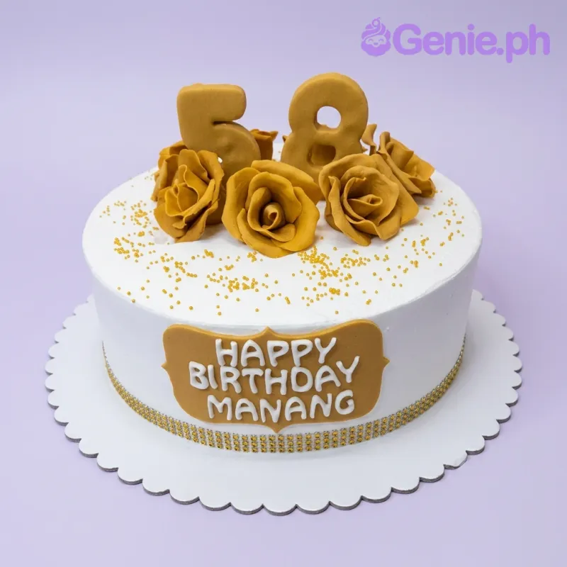 A white round 1-tier Gold Rose Birthday cake with gold number 58 toppers, gold fondant roses, and gold sprinkles. A white round 1-tier Gold Rose Birthday cake with gold number 58 toppers, gold fondant roses, and gold sprinkles.