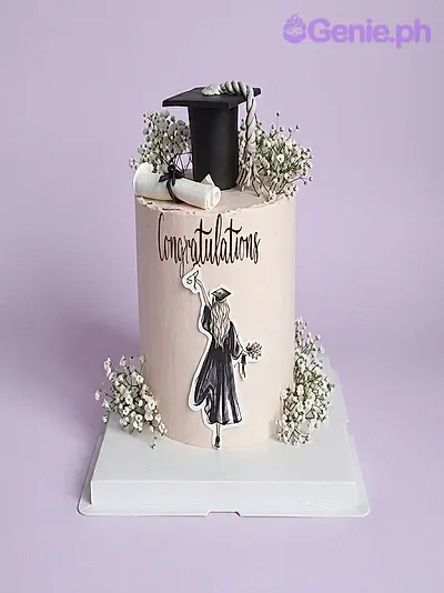 A peach Graduation cake with a black cap, white diploma, graduate printout, and baby's breath flowers. A peach Graduation cake with a black cap, white diploma, graduate printout, and baby's breath flowers.