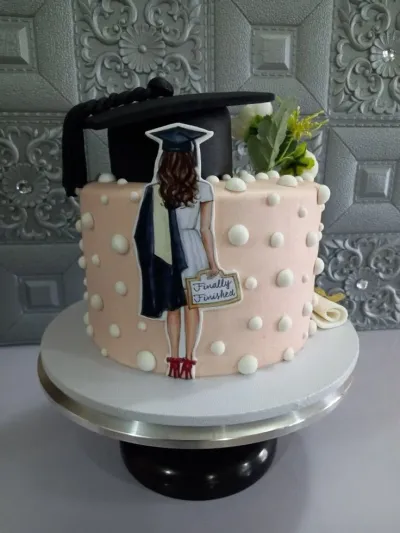 Peach fondant graduation cake with a black graduation cap topper, a printout of a graduate, and white fondant dots. Peach fondant graduation cake with a black graduation cap topper, a printout of a graduate, and white fondant dots.