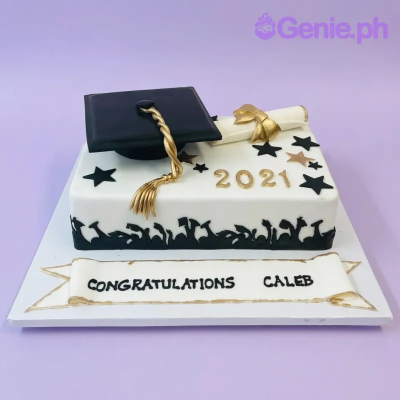 A white rectangle fondant cake themed around Graduation, featuring a black cap, gold tassel, diploma, and '2021' digits, accented with black and gold stars. A white rectangle fondant cake themed around Graduation, featuring a black cap, gold tassel, diploma, and '2021' digits, accented with black and gold stars.