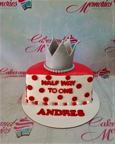 Red and white polka dot half-birthday cake with a silver crown topper and red gumpaste letters. Red and white polka dot half-birthday cake with a silver crown topper and red gumpaste letters.
