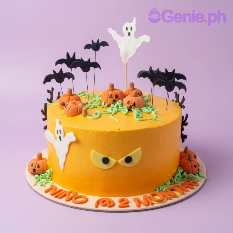 A 1-tier orange Halloween Pumpkin cake with fondant pumpkins, black bats, white ghosts, and 'NIÑO @ 2 MONTHS' text. A 1-tier orange Halloween Pumpkin cake with fondant pumpkins, black bats, white ghosts, and 'NIÑO @ 2 MONTHS' text.