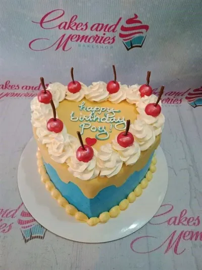 A blue and yellow 1 Tier heart-shaped cake featuring red cherries, white rosettes, a red heart, and "Happy Birthday Poy!" text. A blue and yellow 1 Tier heart-shaped cake featuring red cherries, white rosettes, a red heart, and "Happy Birthday Poy!" text.