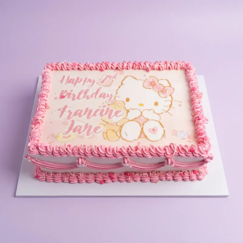 A white and pink Rectangle Hello Kitty cake with an edible image of Hello Kitty and a bear, pink icing rosettes, and heart sprinkles. A white and pink Rectangle Hello Kitty cake with an edible image of Hello Kitty and a bear, pink icing rosettes, and heart sprinkles.