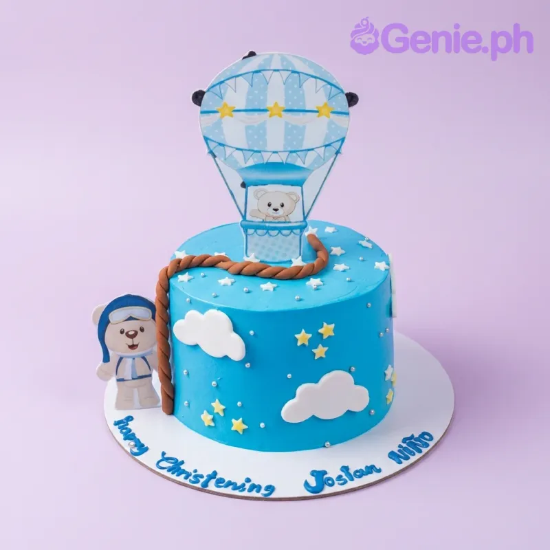 Blue hot air balloon christening cake with teddy bear toppers, white clouds, and yellow stars on a blue icing base. Blue hot air balloon christening cake with teddy bear toppers, white clouds, and yellow stars on a blue icing base.