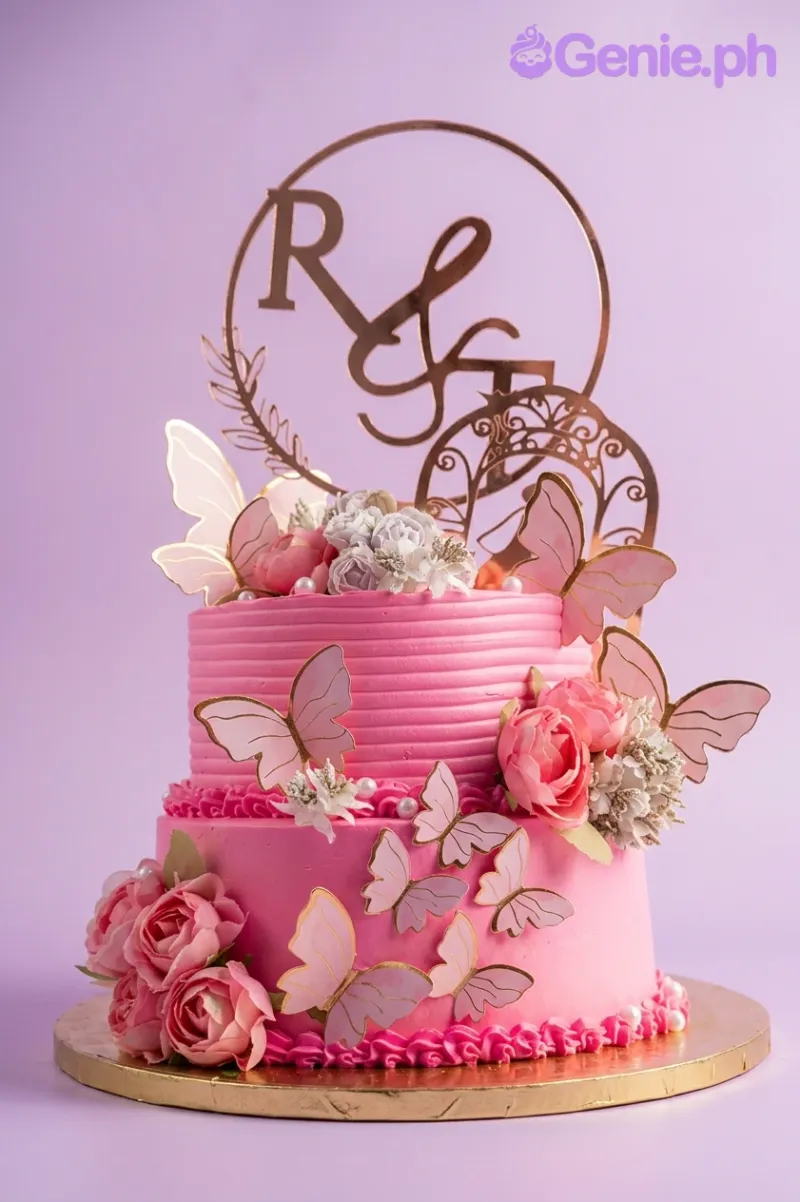 A hot pink 2-tier cake with a Hot Pink Butterfly theme, featuring a rose gold 'R and S' monogram topper and pink butterflies. A hot pink 2-tier cake with a Hot Pink Butterfly theme, featuring a rose gold 'R and S' monogram topper and pink butterflies.