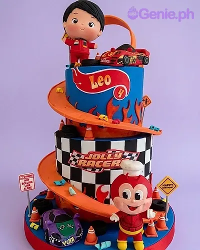 A blue and orange two-tier fondant cake themed Hot Wheels and Jollibee, with racing tracks, checkered patterns, and figures. A blue and orange two-tier fondant cake themed Hot Wheels and Jollibee, with racing tracks, checkered patterns, and figures.