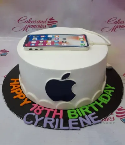 A white 1 Tier cake themed around iPhone, featuring a smartphone printout and black Apple logo, with colorful gumpaste letters on a black board. A white 1 Tier cake themed around iPhone, featuring a smartphone printout and black Apple logo, with colorful gumpaste letters on a black board.