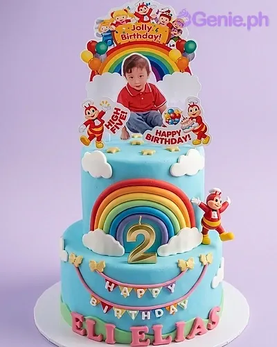 A blue two-tier fondant Jollibee cake, featuring Jollibee toppers, a '2' candle, rainbow, clouds, and personalized text. A blue two-tier fondant Jollibee cake, featuring Jollibee toppers, a '2' candle, rainbow, clouds, and personalized text.