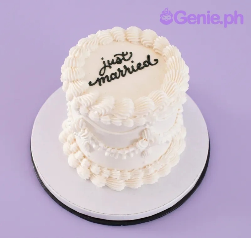 A white and black 1 Tier cake themed around Just Married Minimalist, featuring 'just married' text and piped icing ruffles and swags. A white and black 1 Tier cake themed around Just Married Minimalist, featuring 'just married' text and piped icing ruffles and swags.