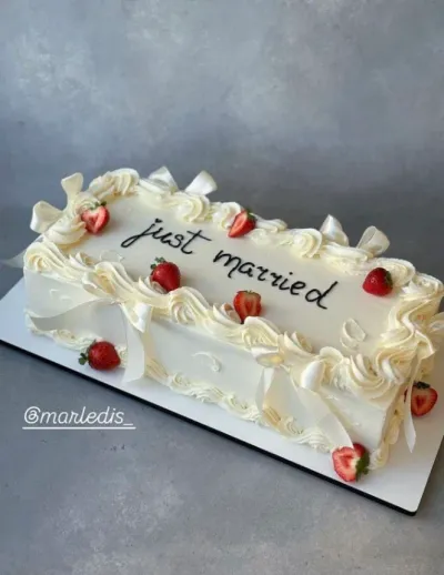 White rectangle cake with smooth soft icing, Just Married theme, fondant strawberries, and white ribbon bows White rectangle cake with smooth soft icing, Just Married theme, fondant strawberries, and white ribbon bows
