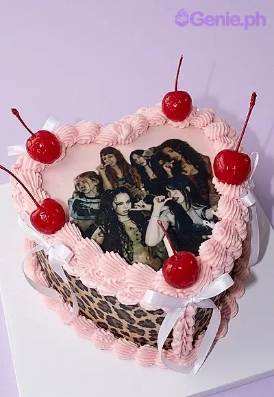 A pink heart-shaped 1 Tier K-pop cake, with a K-pop group photo, leopard print sides, and red cherries. A pink heart-shaped 1 Tier K-pop cake, with a K-pop group photo, leopard print sides, and red cherries.