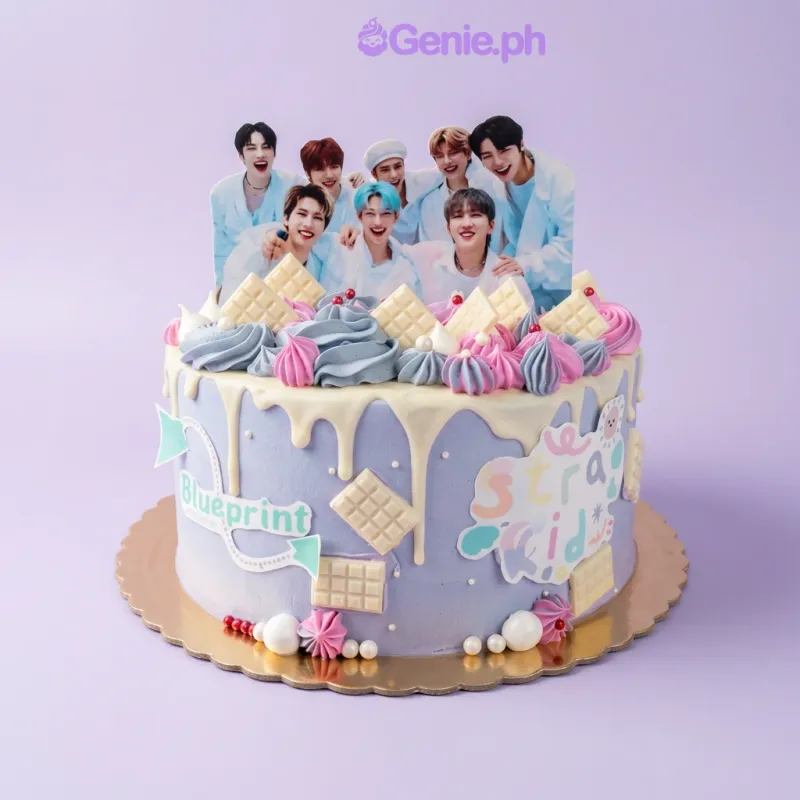 One tier cake with soft blue gradient icing, a Kpop group printout, logo and text printouts, white chocolate bars, pink and blue rosettes, and white pearl sprinkles One tier cake with soft blue gradient icing, a Kpop group printout, logo and text printouts, white chocolate bars, pink and blue rosettes, and white pearl sprinkles