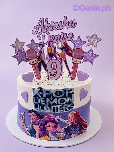A white and purple 1-tier Kpop Demon Hunters themed cake, with character printouts, name banner, and purple stars. A white and purple 1-tier Kpop Demon Hunters themed cake, with character printouts, name banner, and purple stars.