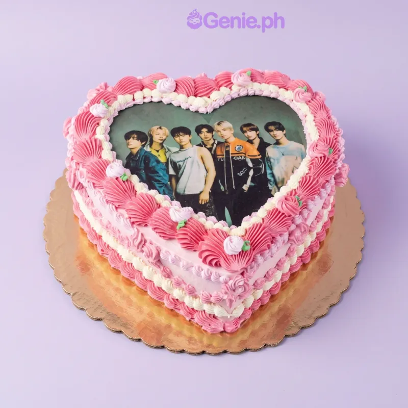 One tier Kpop Heart cake with soft pink icing, a photo print of a K-pop group, and white and pink piped icing rosettes One tier Kpop Heart cake with soft pink icing, a photo print of a K-pop group, and white and pink piped icing rosettes