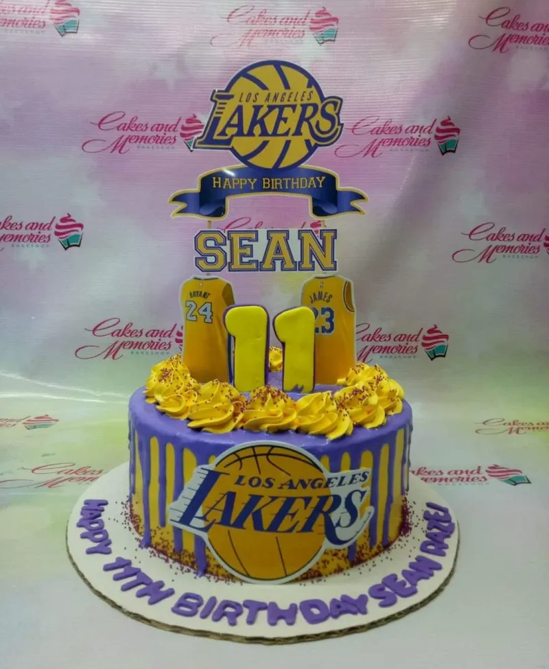 Purple Lakers themed birthday cake with yellow icing swirls, basketball logo, and jersey toppers for an 11th birthday. Purple Lakers themed birthday cake with yellow icing swirls, basketball logo, and jersey toppers for an 11th birthday.