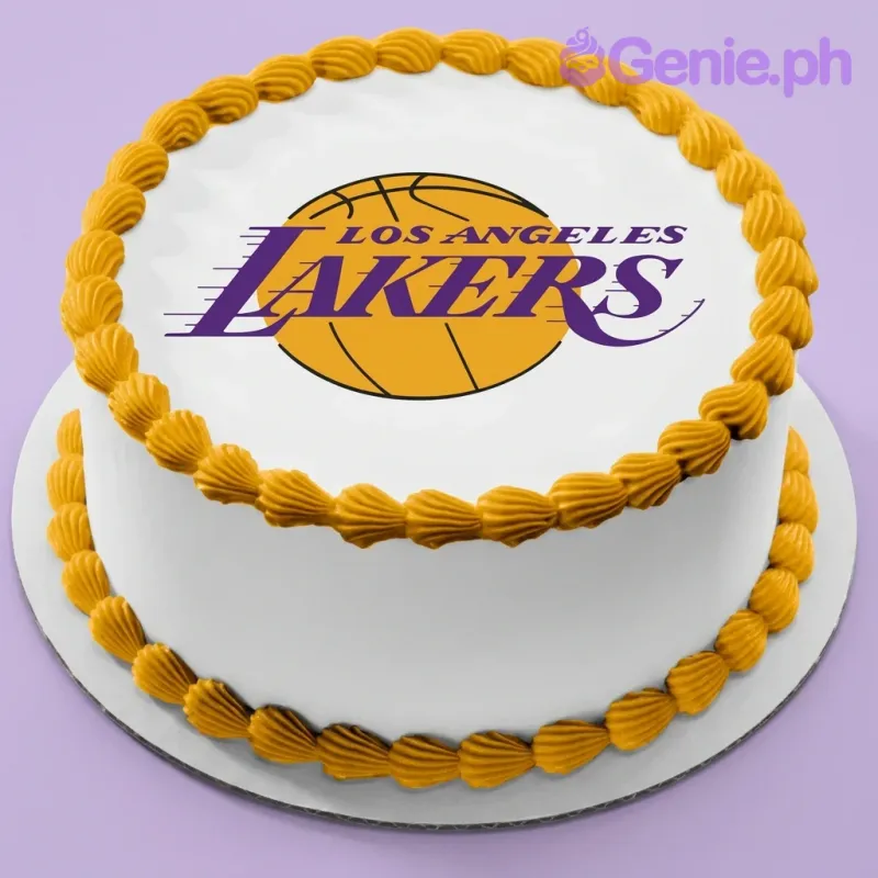 A white round cake with yellow icing borders, themed for Lakers Basketball, featuring a large Los Angeles Lakers logo. A white round cake with yellow icing borders, themed for Lakers Basketball, featuring a large Los Angeles Lakers logo.