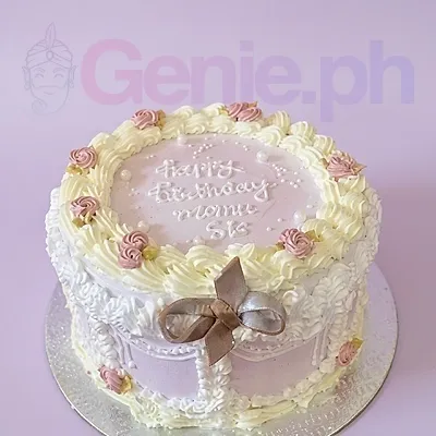 A lavender 1-tier cake themed Lavender Minimalist, featuring a brown gumpaste bow, white piped borders, and pink rosettes. A lavender 1-tier cake themed Lavender Minimalist, featuring a brown gumpaste bow, white piped borders, and pink rosettes.