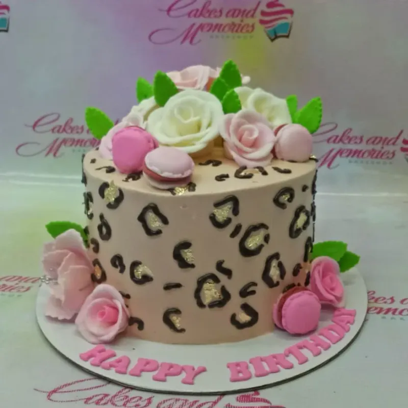 A tan and pink 1 Tier Leopard Print cake, featuring white and pink roses, pink macarons, and 'HAPPY BIRTHDAY' text. A tan and pink 1 Tier Leopard Print cake, featuring white and pink roses, pink macarons, and 'HAPPY BIRTHDAY' text.