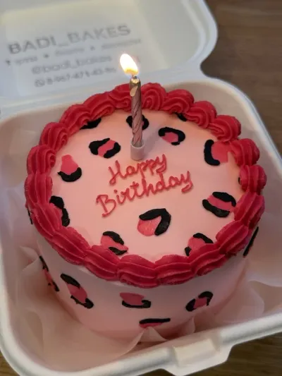 Soft pink bento cake with smooth icing, leopard print spots, piped pink shell border, and a silver spiral candle Soft pink bento cake with smooth icing, leopard print spots, piped pink shell border, and a silver spiral candle