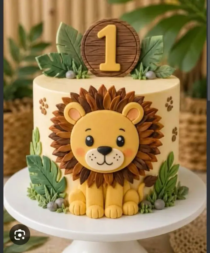 Light yellow 1-tier cake with soft icing, a lion safari first birthday theme, and fondant jungle leaves Light yellow 1-tier cake with soft icing, a lion safari first birthday theme, and fondant jungle leaves
