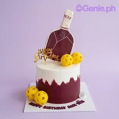 White and dark red single tier cake with a printed liquor bottle topper and yellow ball decorations White and dark red single tier cake with a printed liquor bottle topper and yellow ball decorations