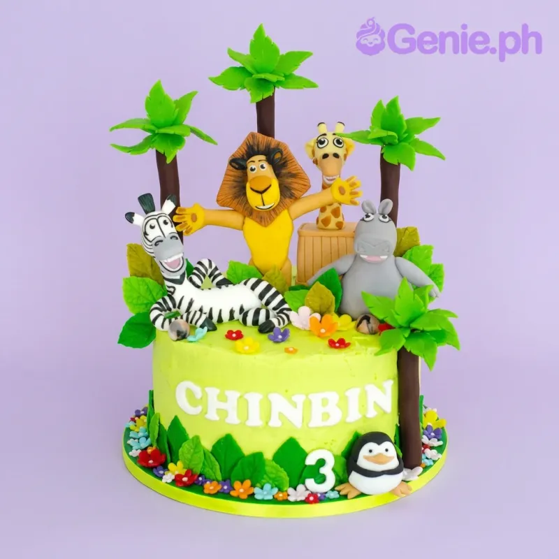 A light green 1-tier Madagascar Safari cake, with 3D fondant figures of main characters and jungle foliage. A light green 1-tier Madagascar Safari cake, with 3D fondant figures of main characters and jungle foliage.