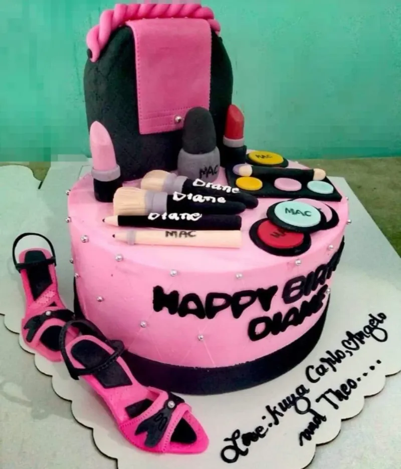 A pink and black 1 Tier Fondant cake themed around Makeup, featuring a makeup bag, high-heeled shoes, lipsticks, and makeup brushes. A pink and black 1 Tier Fondant cake themed around Makeup, featuring a makeup bag, high-heeled shoes, lipsticks, and makeup brushes.