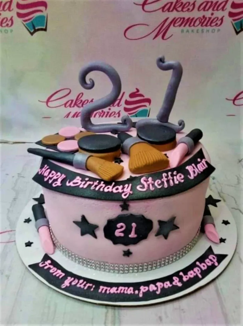 A pink 1 Tier Fondant makeup-themed cake, featuring a large purple number 21, fondant makeup brushes, lipstick, and compacts. A pink 1 Tier Fondant makeup-themed cake, featuring a large purple number 21, fondant makeup brushes, lipstick, and compacts.