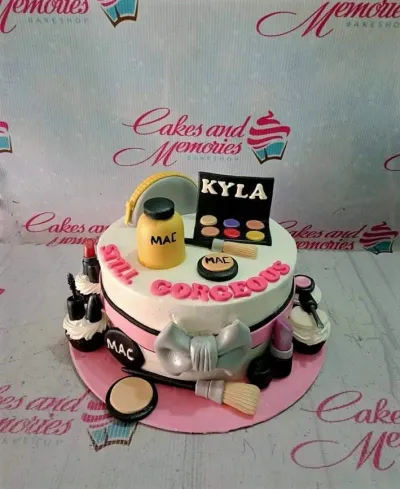 A white 1-tier makeup themed cake, featuring a makeup palette, foundation bottle, silver bow, cosmetic details, and pink ribbon. A white 1-tier makeup themed cake, featuring a makeup palette, foundation bottle, silver bow, cosmetic details, and pink ribbon.